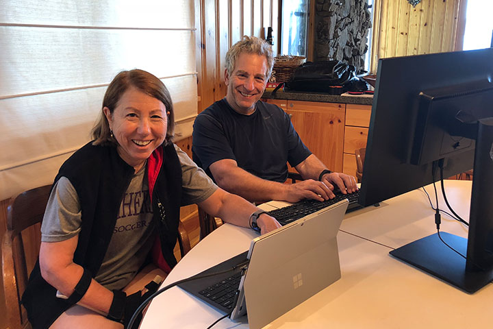 man and woman using their computers
