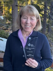 Blonde woman holding a Stroke Hero Award