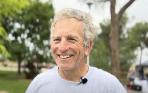 Steve Zuckerman, a white man with grey hair, smiles at the camera. 